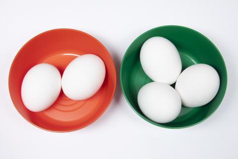 To skåler, en rød med to egg og en grønn med tre egg