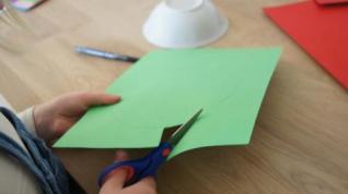 Barn som klipper i grønt papir
